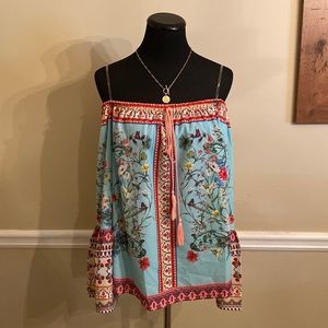 Floral off-the-shoulder Umgee blouse w/ tassels on front.